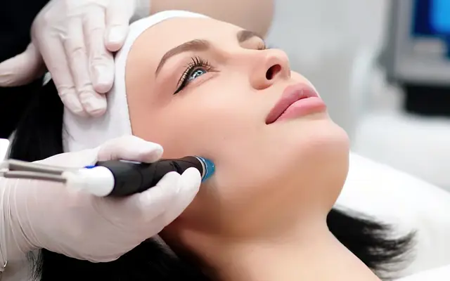 Femme appliquant une crème hydratante sur sa jambe avant une séance d'épilation laser